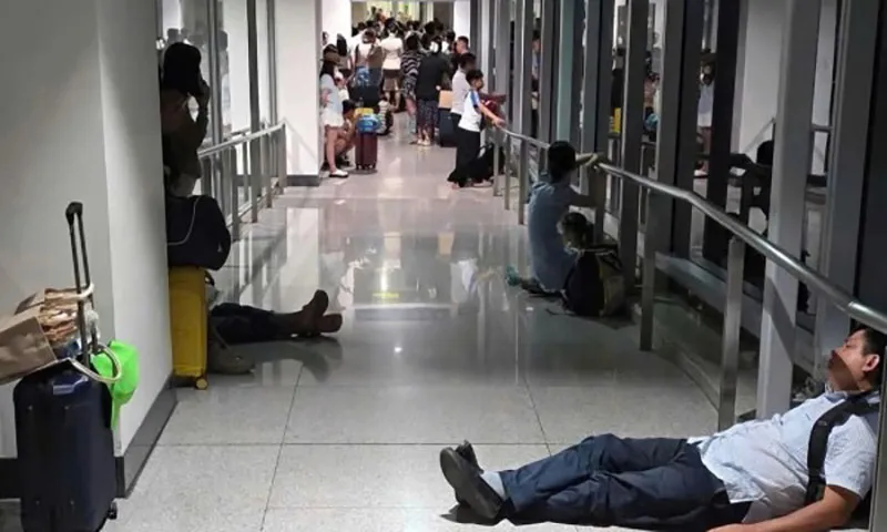 Hành khách nằm ngồi la liệt trong hành lang ống lồng do cánh cửa dẫn vào nhà ga bị khóa Ảnh NVCC