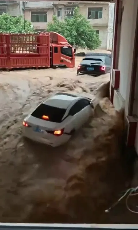 Nước lũ kéo hàng loạt xe ô tô xuống gầm tòa nhà