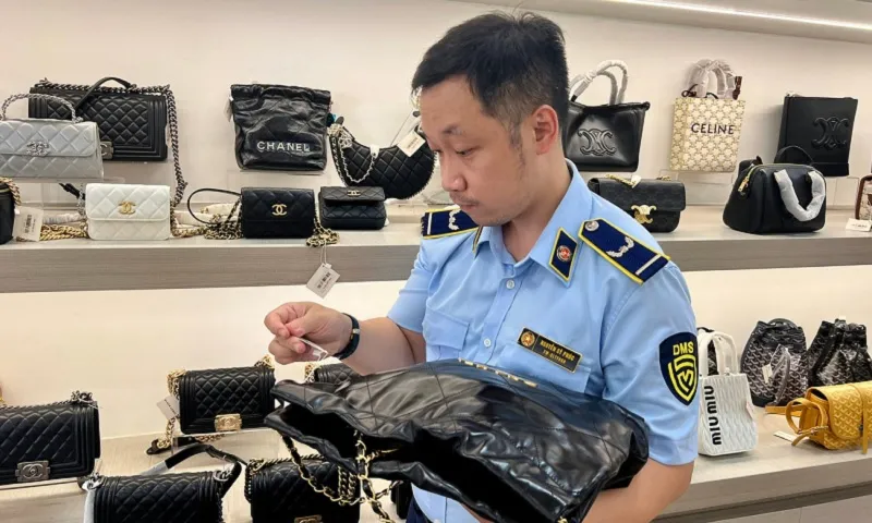 Lực lượng chức năng kiểm tra một cửa hàng bán túi xách có dấu hiệu giả mạo thương hiệu nổi tiếng