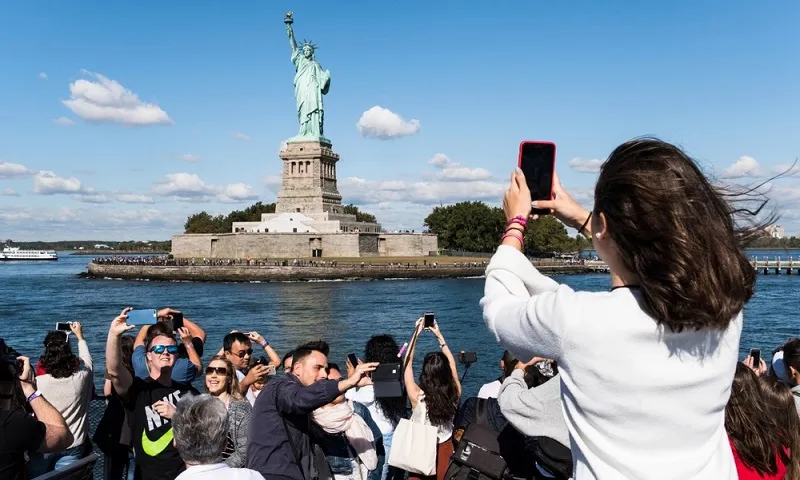 du lịch Mỹ Du khách đến chụp ảnh tượng Nữ thần Tự Do ở New York, Mỹ - Ảnh TTG Asia