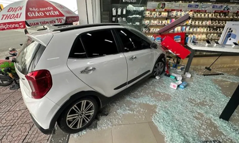 Xe hơi con leo lề đâm vào cửa hàng điện thoại