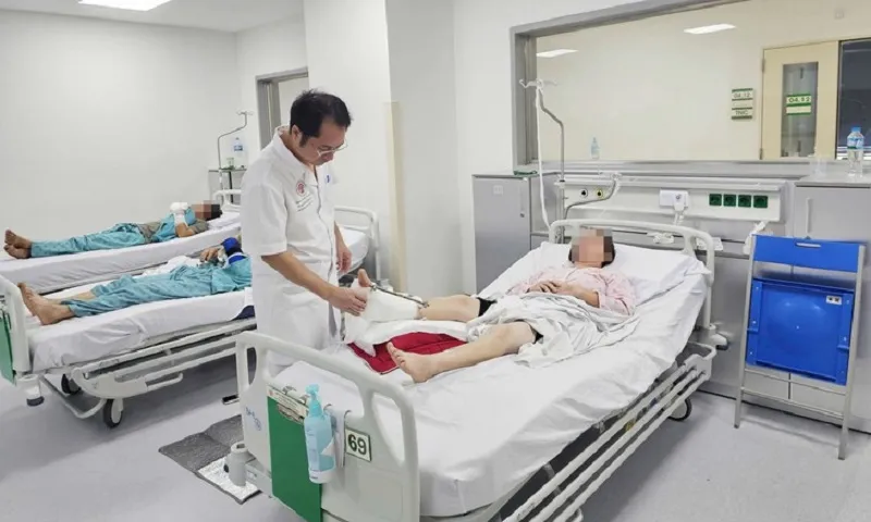 Bác sĩ Bệnh viện Trung ương Quân đội 108 thăm khám cho bệnh nhân sau khi nối liền chân - Ảnh BVCC