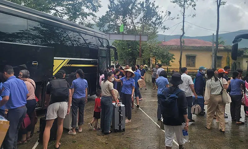 Các nhân viên đường sắt hỗ trợ hành khách chuyển tải giữa các chuyến tàu qua khu vực ngập nước