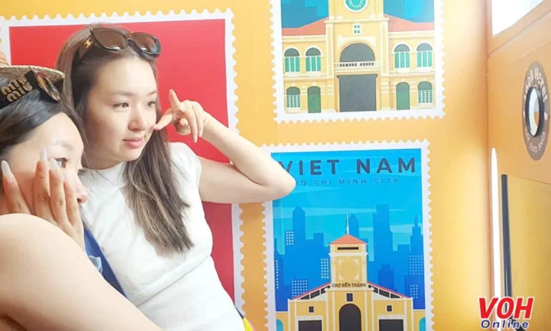 Du khách trải nghiệm chụp ảnh tạo tem thư cá nhân tại Bưu điện Trung tâm Sài Gòn