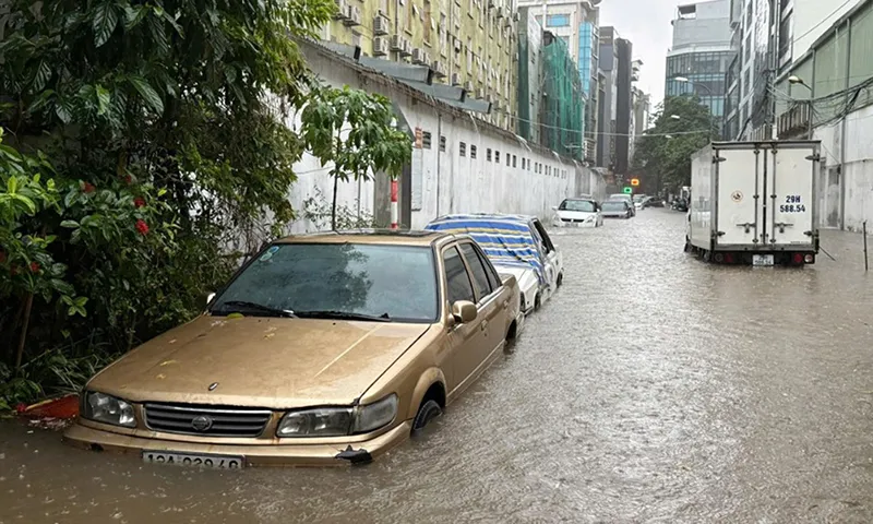 Trên một tuyến đường giao cắt với Lê Đức Thọ, dãy ôtô để trên vỉa hè bị ngập đến thân xe 2