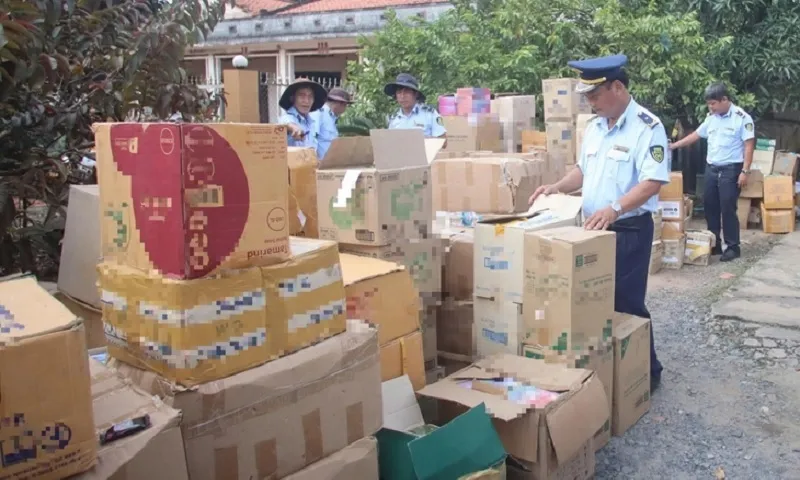 Lực lượng chức năng kiểm tra kho hàng nghi nhập lậu giả mạo nhãn hiệu hàng giả - Ảnh T