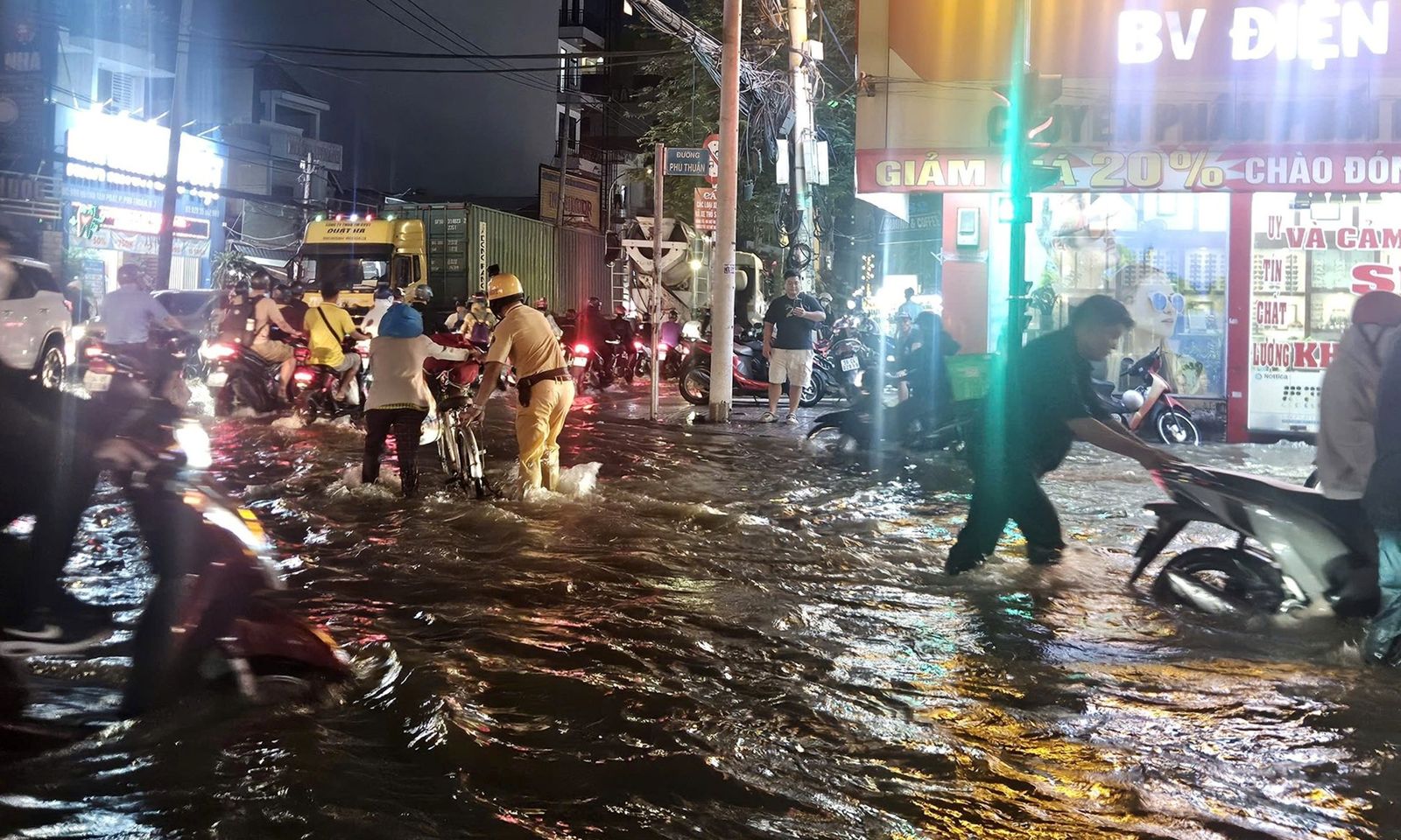 TPHCM: Nước triều dâng cao, cảnh sát giao thông xuống đường lội nước đẩy xe cho người dân