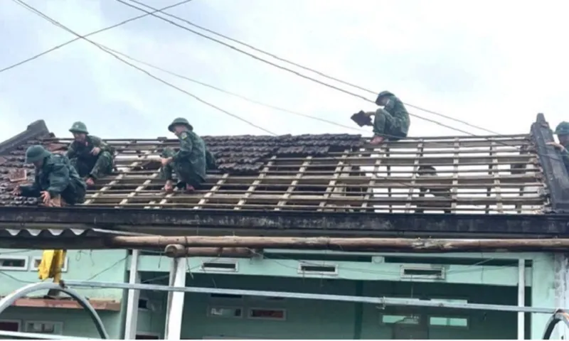 Bộ đội giúp các hộ dân lợp lại mái nhà sau lốc xoáy