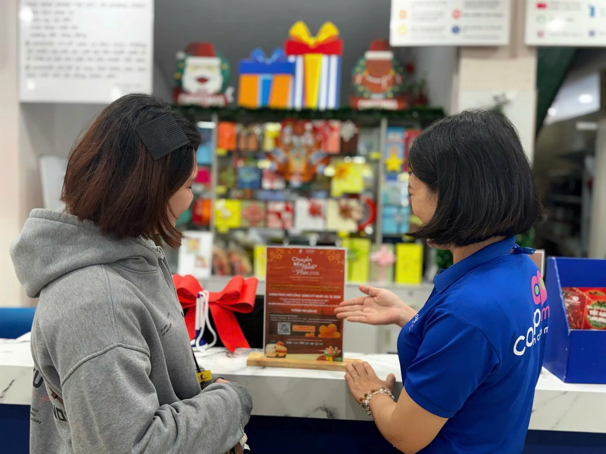 Hinh 2-Nhân viên Co.opmart tư vấn thông tin về chương trình cho khách hàng