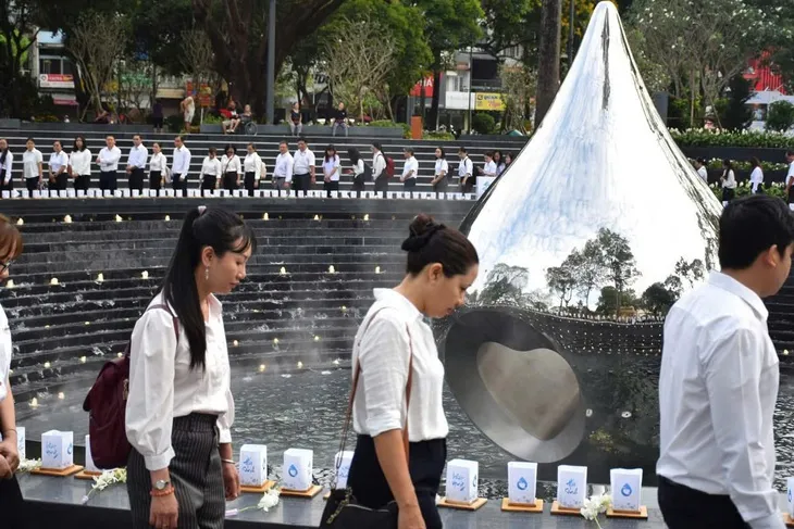 Nghi thức dâng hoa, mặc niệm tưởng nhớ đồng bào đã mất vì COVID-19 và đi một vòng đài tưởng niệm hình giọt nước - Ảnh HCDC cung cấp