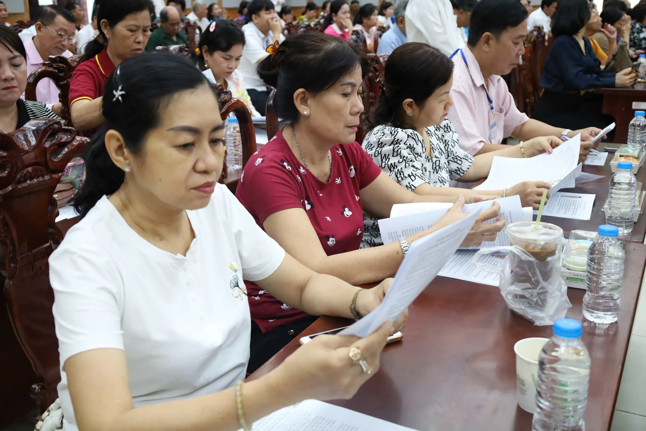 Cử tri xã Tân Nhựt chăm chú xem chương trình hành động của ứng cử viên