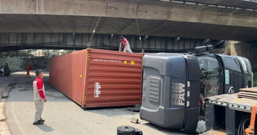 Xe container chở gần 30 tấn hàng lật dưới gầm cầu Đồng Nai