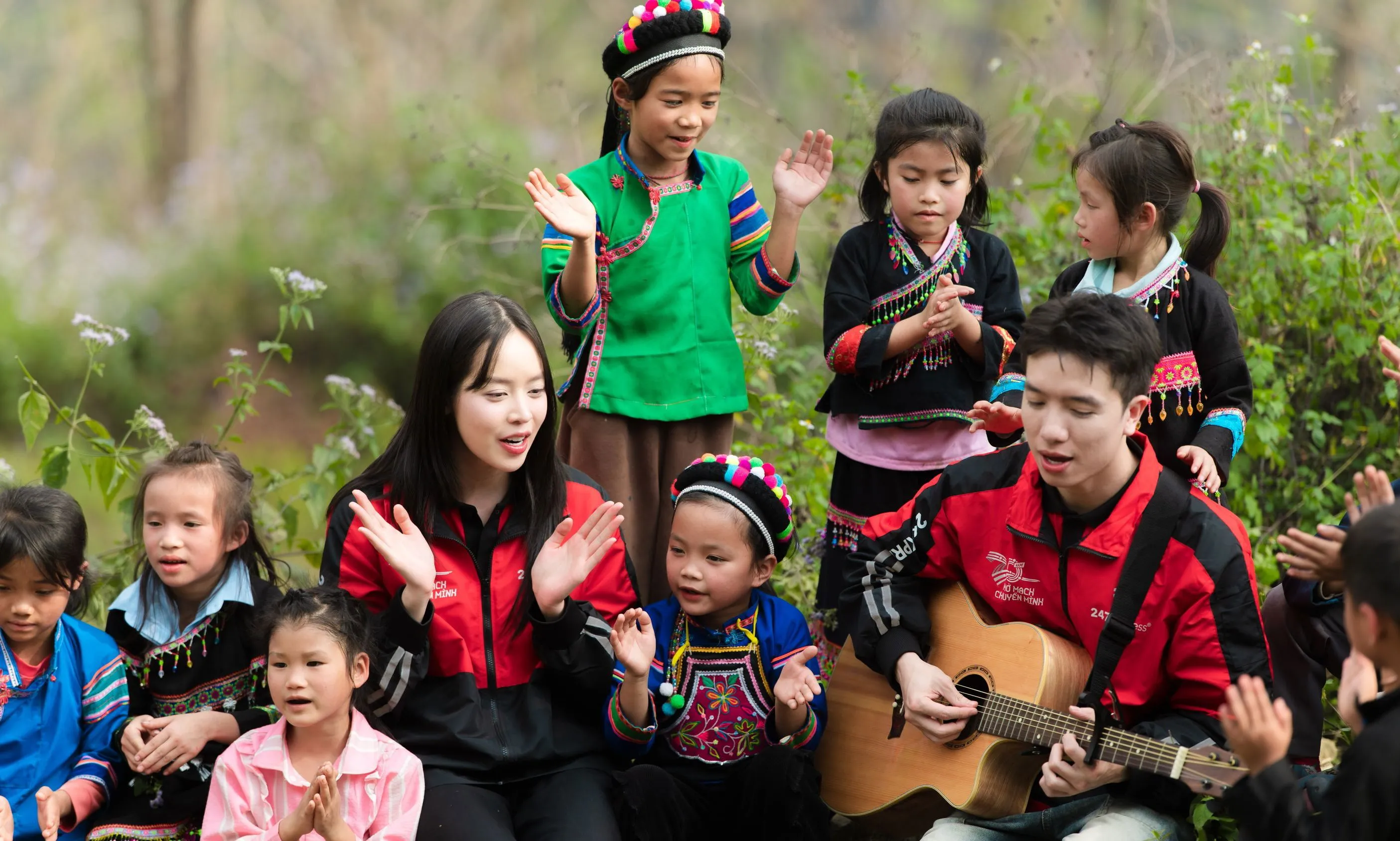 Hoa hậu Thanh Thủy đứng hát giữa sân trường đất, khán giả là học sinh vùng núi