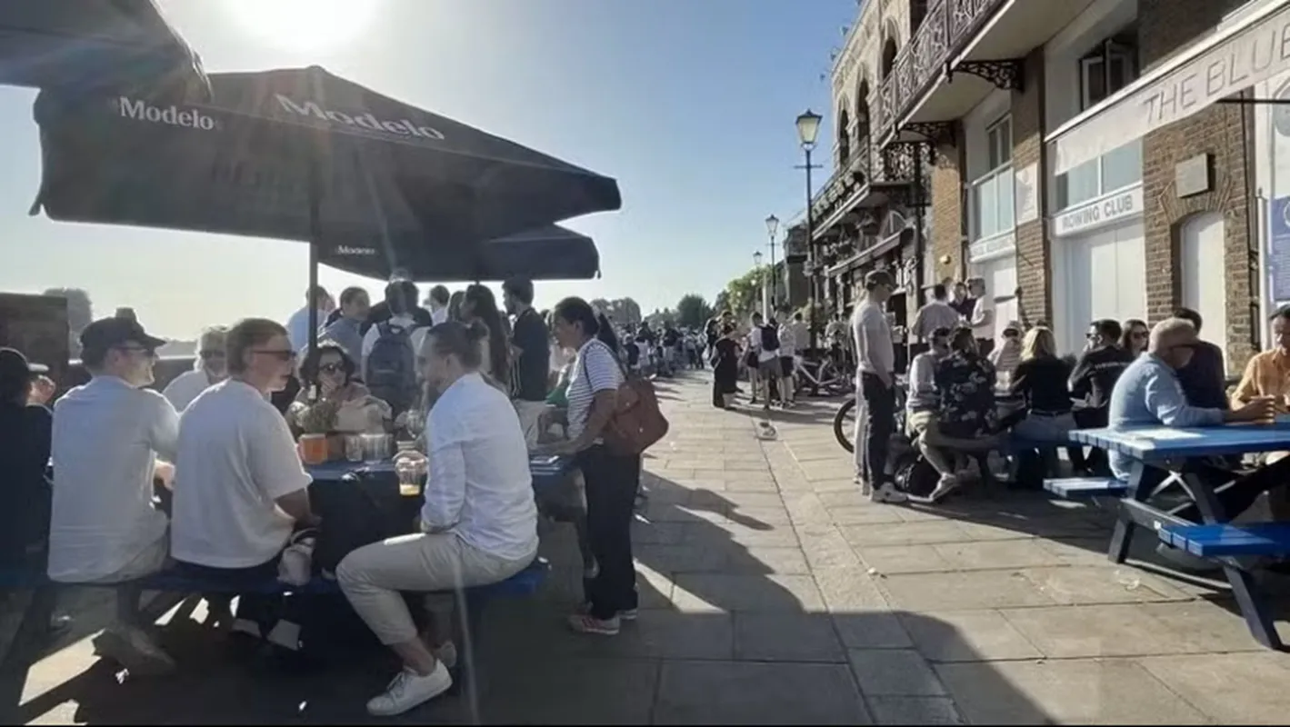 Người dân thưởng thức đồ uống tại các pub ven sông Thames trong ngày nắng nóng. Ảnh TTXVN