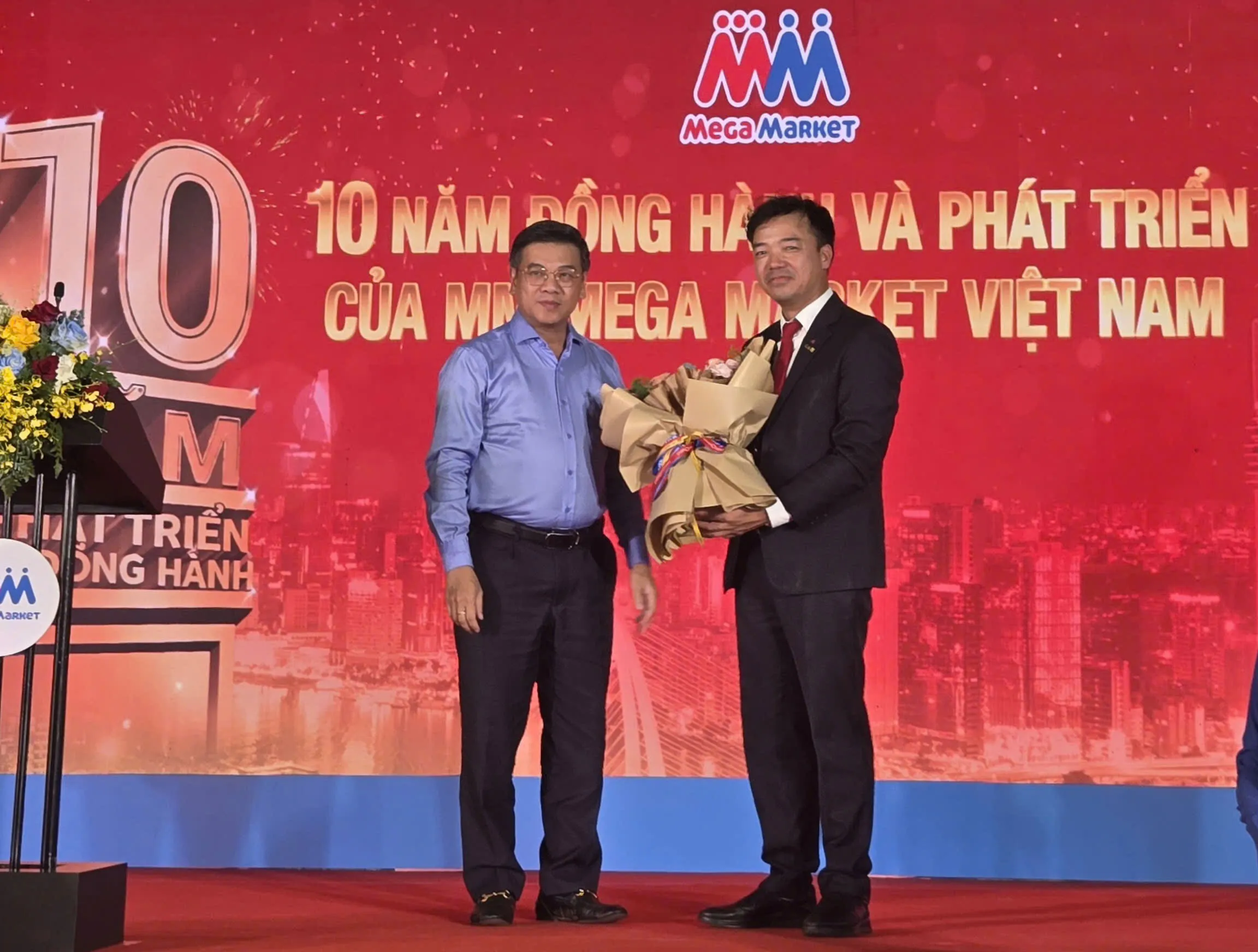 Ông Nguyễn Văn Dũng, Phó Chủ tịch Hội đồng nhân dân TPHCM tặng hoa chúc mừng kỷ niệm 10 năm định hình và phát triển của MM Mega Market Việt Nam - Ảnh Bá Nam