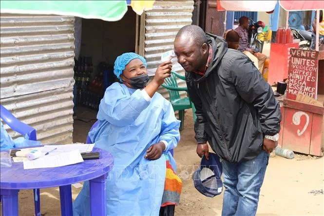 Nhân viên y tế kiểm tra thân nhiệt cho người dân tại Bunia, tỉnh Ituri, CHDC Congo. Ảnh: THX/TTXVN