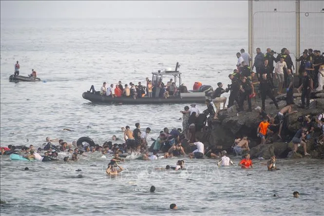 Hàng trăm người di cư tìm cách bơi từ Maroc sang Ceuta, vùng lãnh thổ của Tây Ban Nha ở Bắc Phi, ngày 30/7/2026. Ảnh: AA/TTXVN