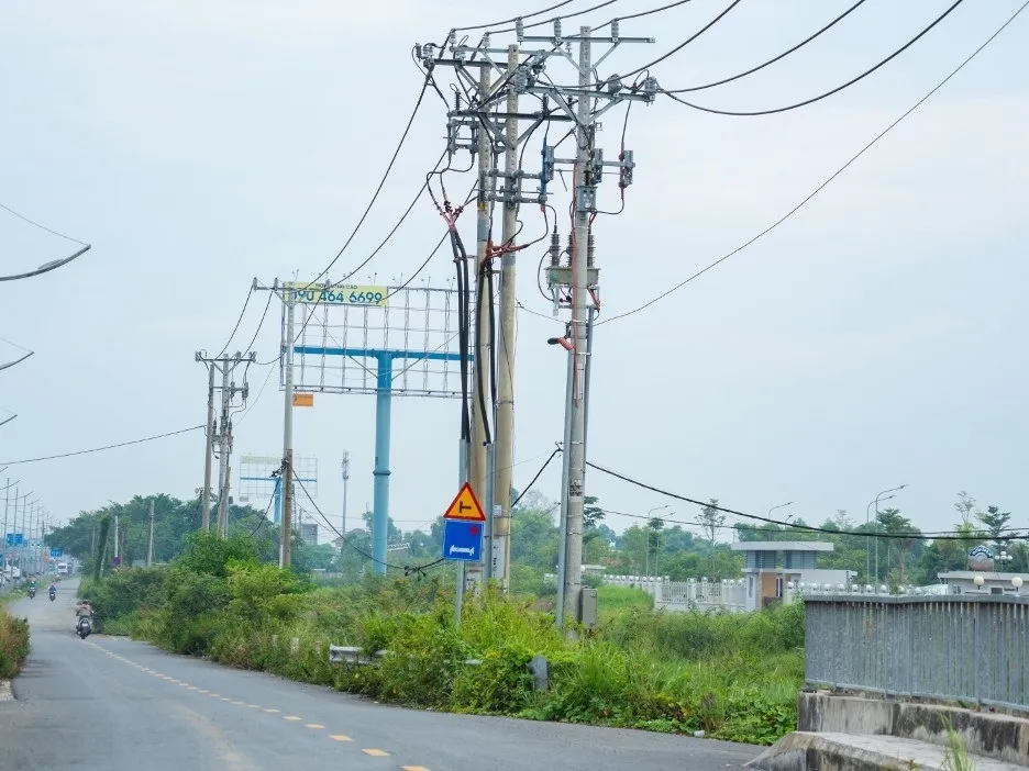 Dọc khu vực nút giao Chợ Đệm, nhiều trụ điện trung thế, đường dây cáp viễn thông, đường ống cấp nước… vẫn nằm trong phạm vi cần xử lý, nhà thầu không thể thi công vì không bảo đảm điều kiện an toàn - Ảnh: VOV
