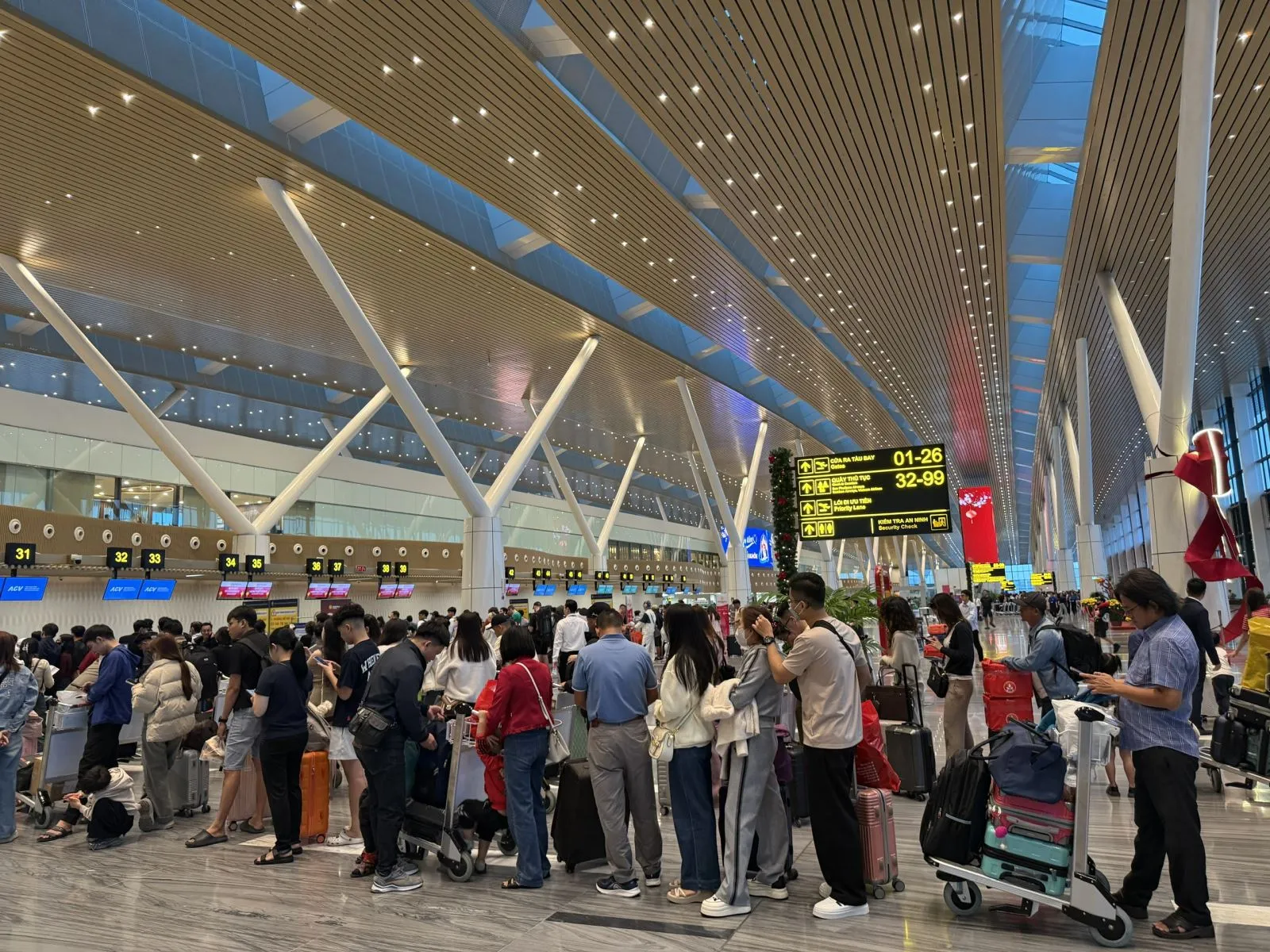 Người dân xếp hàng chờ làm thủ tục tại nhà ga T3. Ảnh: Hoàng Tuyết/Báo Tin tức và Dân tộc