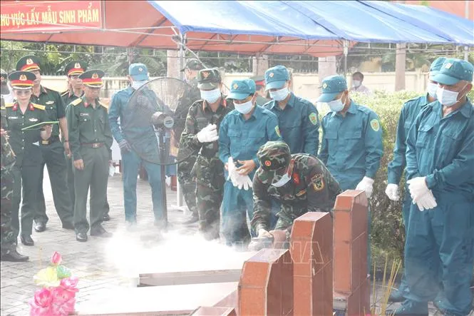 Đơn vị nghiệp vụ triển khai bốc mộ hài cốt liệt sĩ đối với mộ chưa xác định được thông tin tại nghĩa trang liệt sĩ xã Đức Linh (Lâm Đồng). Ảnh: Nguyễn Thanh/TTXVN