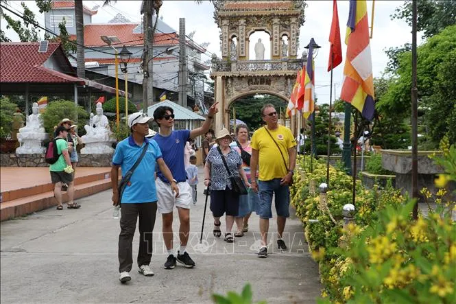 Du khách quốc tế tham quan Di tích lịch sử - văn hóa cấp quốc gia chùa Vĩnh Tràng (phường Mỹ Phong, tỉnh Đồng Tháp) (Ảnh: Hồng Thái/TTXVN)