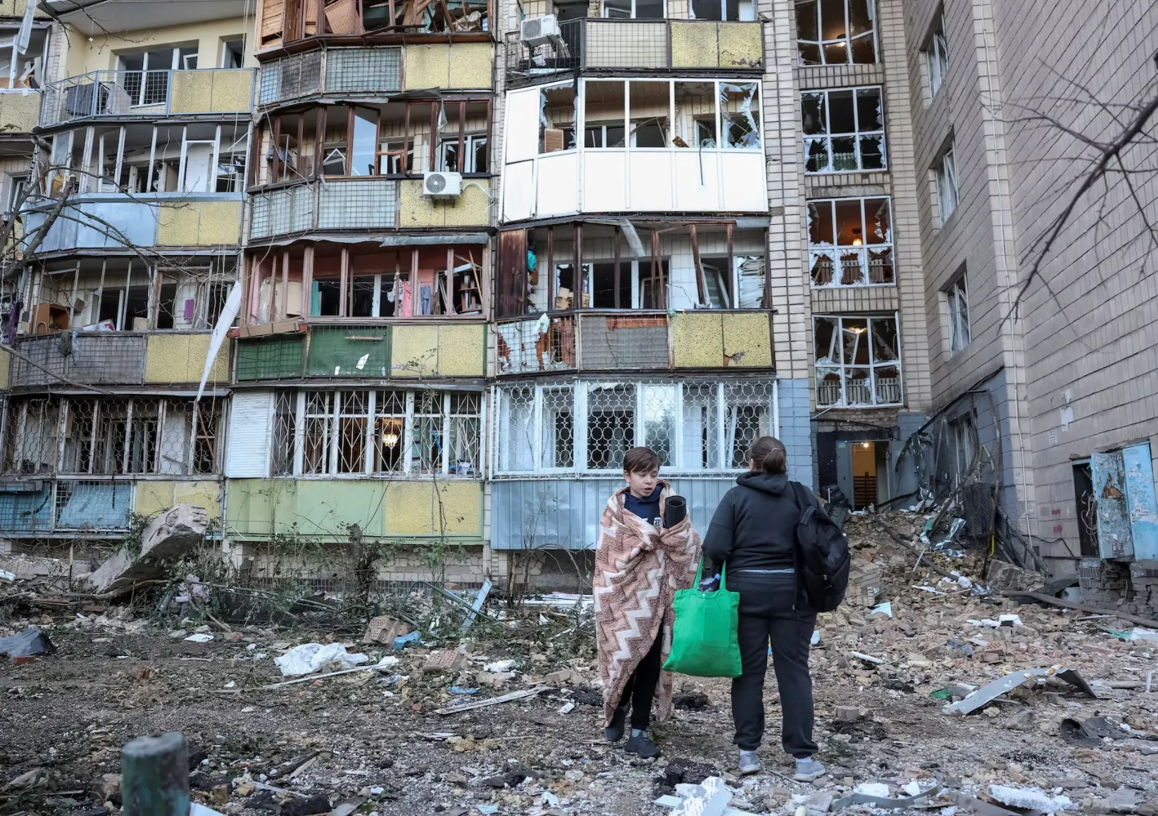 Người dân Ukraine đứng bên ngoài một tòa nhà bị hư hại sau cuộc tấn công của Nga ngày 20-8 - Ảnh REUTERS
