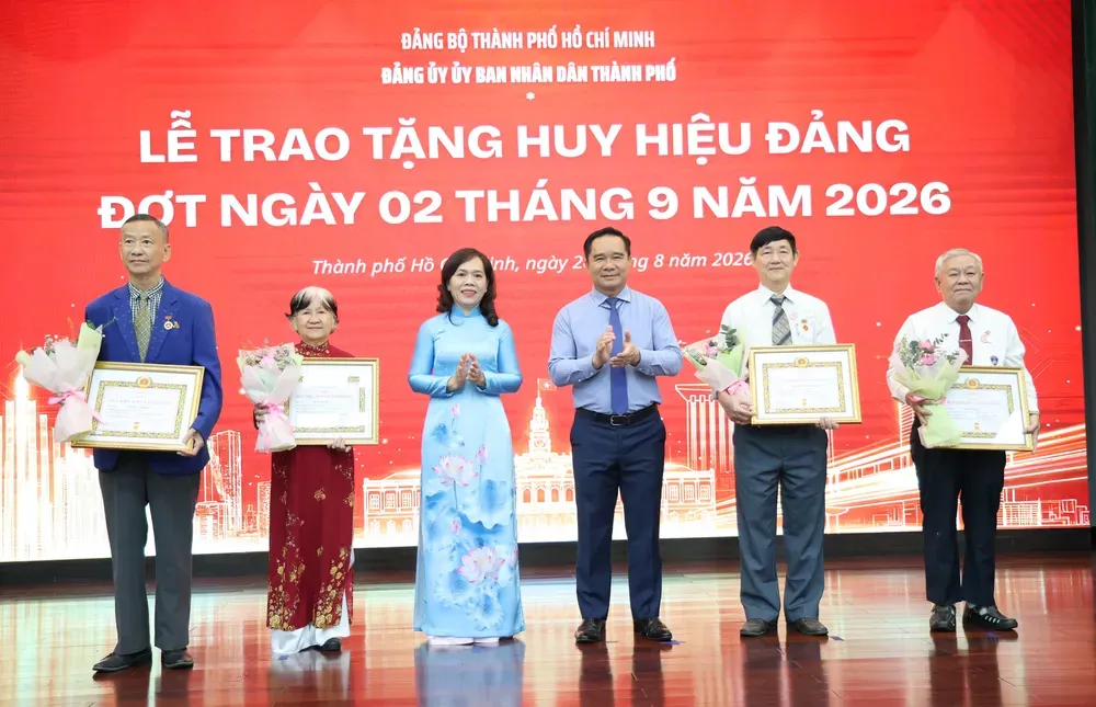 Đồng chí Nguyễn Văn Được, Bí thư Đảng ủy UBND TP.HCM, Chủ tịch UBND TP.HCM và đồng chí Nguyễn Thanh Xuân, Phó Bí thư Đảng ủy UBND TP.HCM trao Huy hiệu Đảng. Ảnh: LÊ THOA