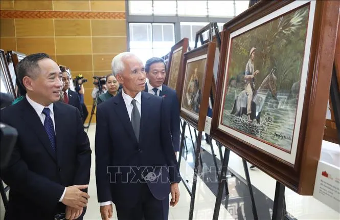 Đồng chí Khamphan Pheuiyavong, Ủy viên Bộ Chính trị, Trưởng ban Tuyên huấn Trung ương Lào và đại biểu tham quan triển lãm. Ảnh: Xuân Tú/TTXVN