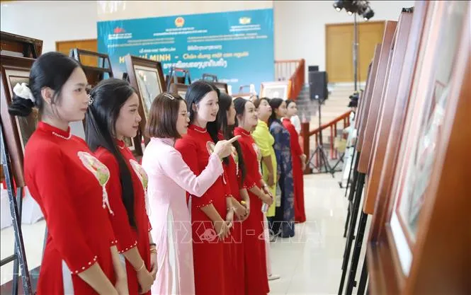 Cô giáo Trường Song ngữ Lào - Việt Nam Nguyễn Du giới thiệu cho học sinh về Bác Hồ tại Triển lãm. Ảnh: Xuân Tú/TTXVN