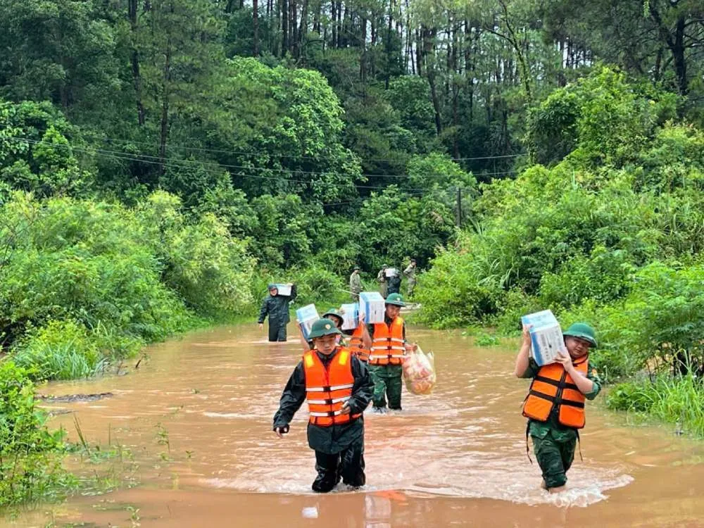 Cán bộ, chiến sĩ quân đội của Đồn Biên phòng Cửa khẩu Chi Ma (Lạng Sơn) vượt nước ngập, vận chuyển lương thực, nhu yếu phẩm hỗ trợ người dân vùng bị cô lập do mưa lũ - Ảnh: Chinhphu.vn
