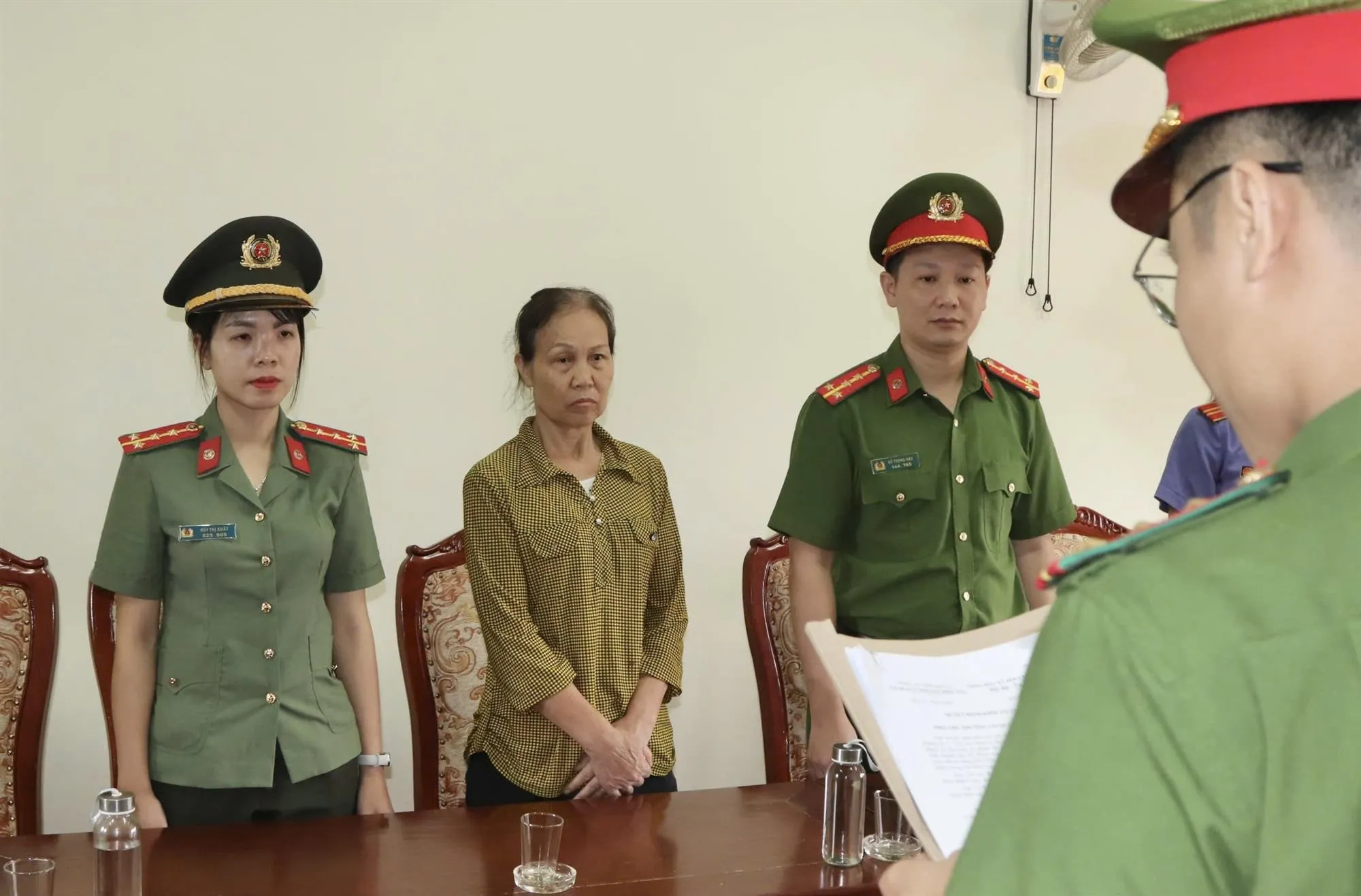 Cảnh sát tống đạt các quyết định và lệnh tố tụng đối với bà Tưởng Thị Hòe, sau khi Viện KSND cùng cấp phê chuẩn - Ảnh: Cao Thiên - Thanh Niên
