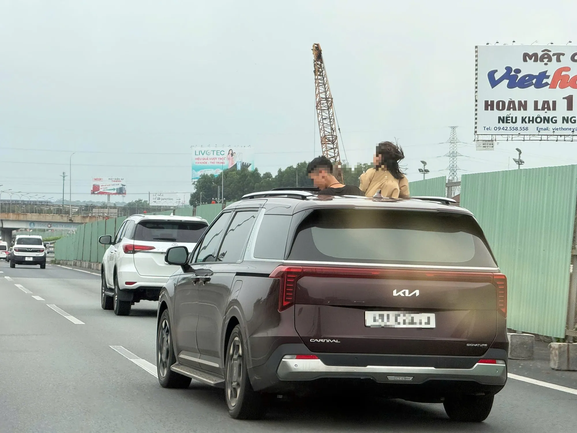 Hai đứa trẻ thò đầu ra cửa sổ trời khi ô tô đang chạy trên cao tốc - Ảnh cắt từ clip