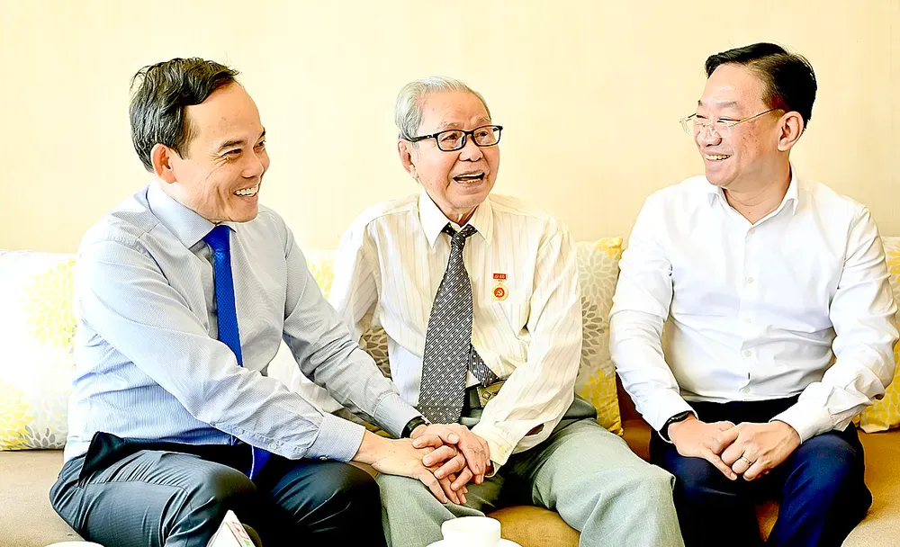 Bí thư Thành ủy TP.HCM Trần Lưu Quang và Bí thư Đảng ủy phường An Khánh Lê Trần Kiên trò chuyện với đồng chí Nguyễn Văn Tư tại buổi đến trao Huy hiệu Đảng, ngày 27/8. Ảnh: VĂN MINH