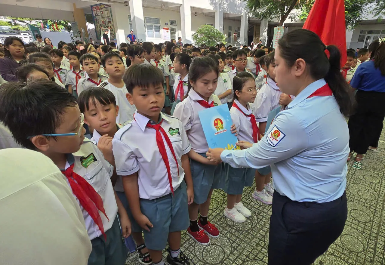 Chị Trịnh Thị Hiền Trân, Phó Bí thư Thành Đoàn, Chủ tịch Hội đồng Đội Thành phố trao cấp hiệu, quyết định và cờ Đội cho Ban chỉ huy các chi đội - Ảnh Bá Nam