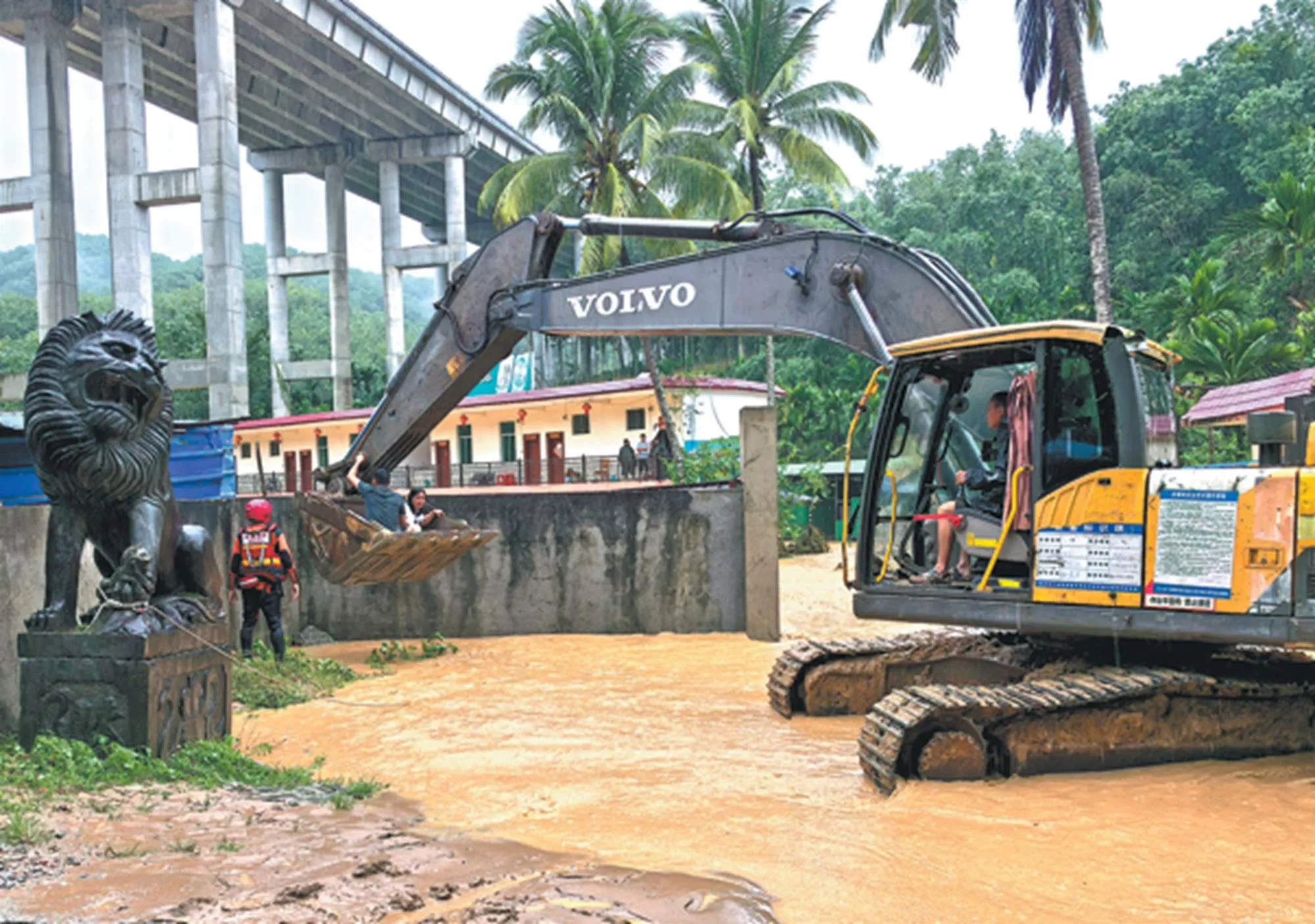 Lực lượng cứu hỏa sử dụng máy xúc để giải cứu 14 người bị mắc kẹt do nước lũ tại Ngũ Chỉ Sơn, tỉnh Hải Nam, vào hôm 14/9 - Ảnh: China Daily