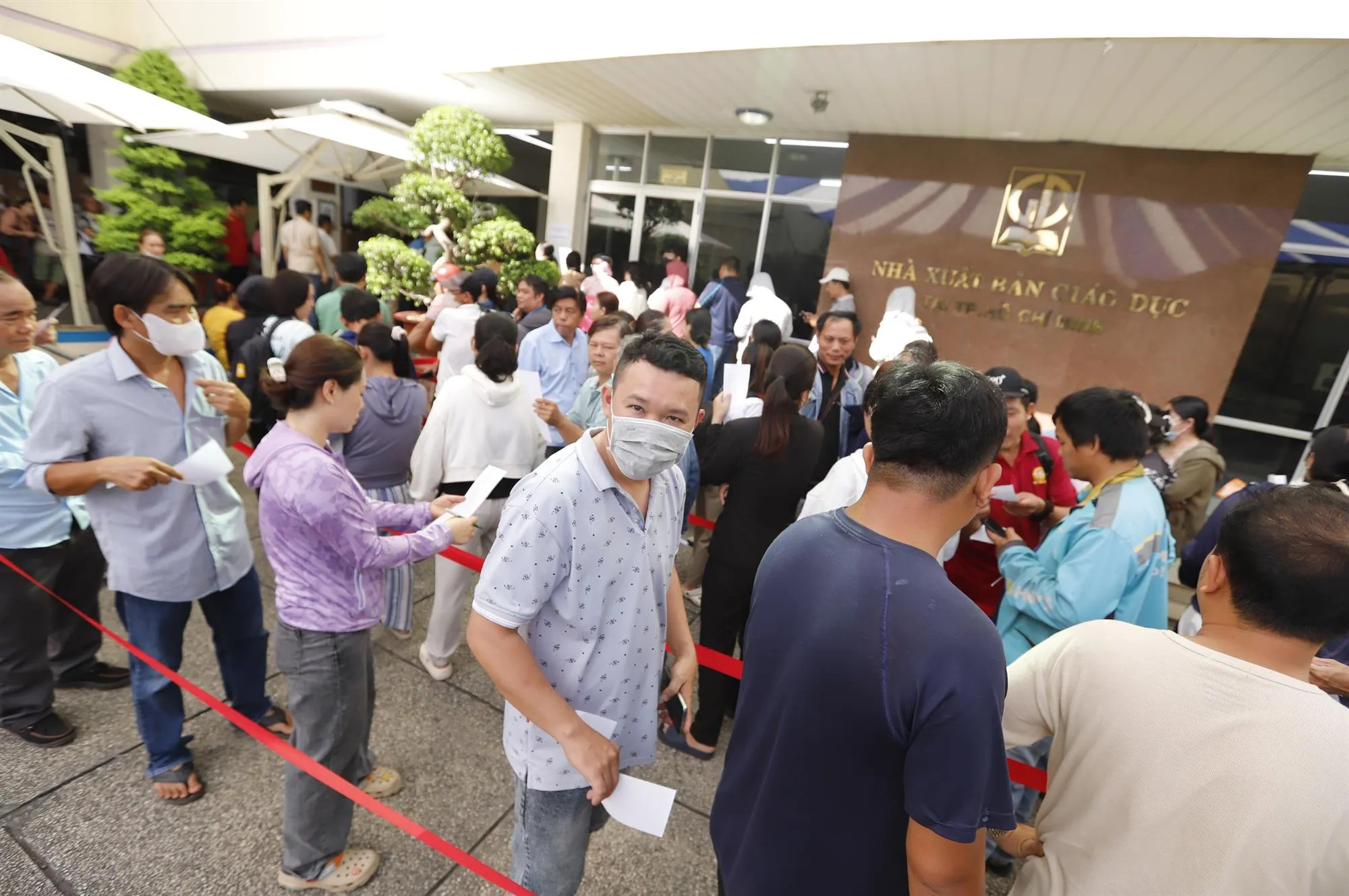 Phụ huynh xếp hàng dài mua sách giáo khoa ở Nhà xuất bản Giáo dục Việt Nam tại TP. Hồ Chí Minh - Ảnh: Như Hùng - TTO