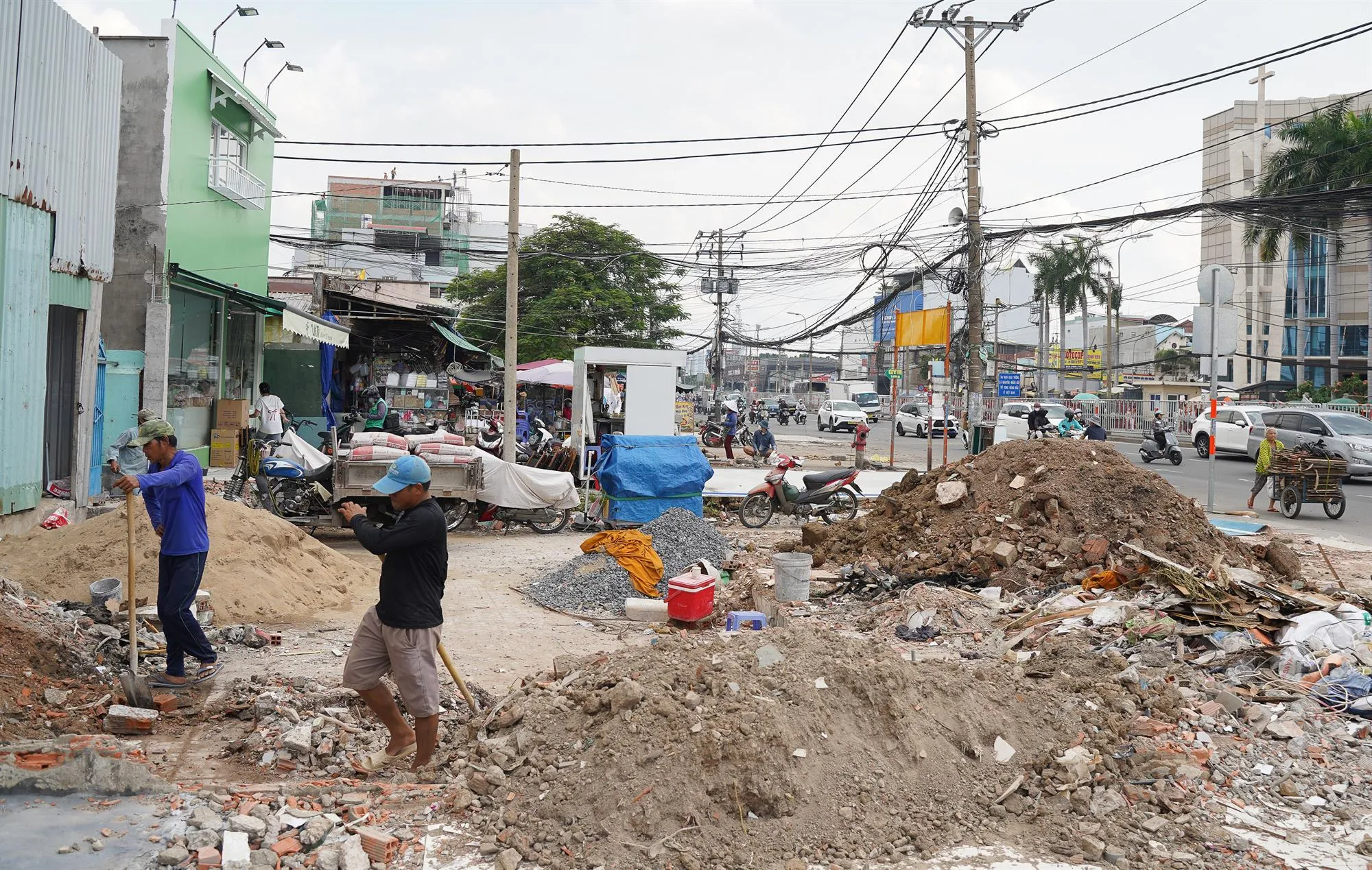 Công nhân thu dọn phế liệu để bàn giao mặt bằng cho chủ đầu tư thi công dự án Nâng cấp, mở rộng quốc lộ 13 - Ảnh: Phương Uyên - SGGP