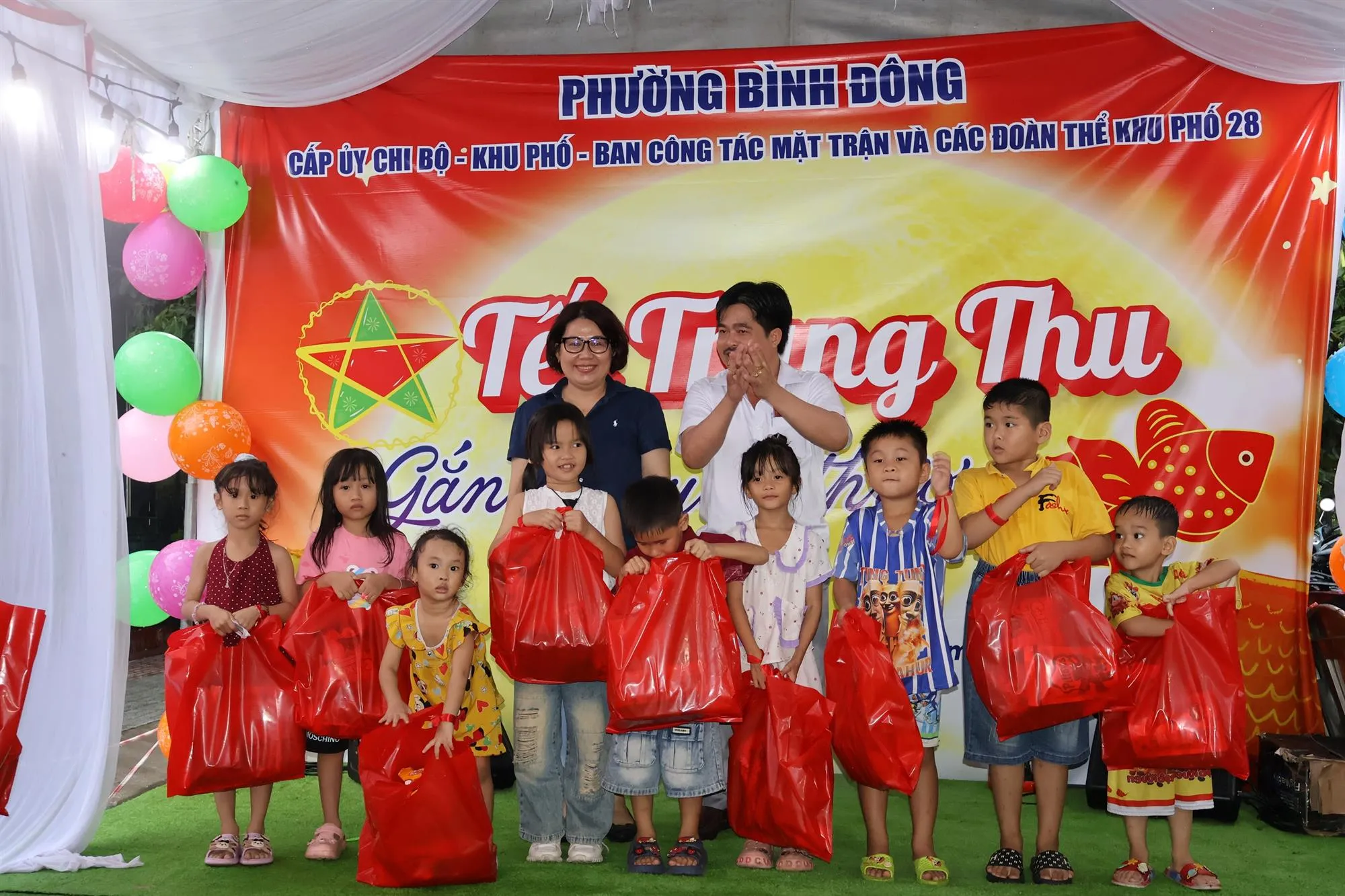 Đồng chí Huỳnh Mỹ Ngọc, Phó Bí thư thường trực Đảng ủy phường Bình Đông cùng Bí thư chi bộ khu phố và ban ngành đoàn thể khu phố 28 trao quà đến các em thiếu nhi