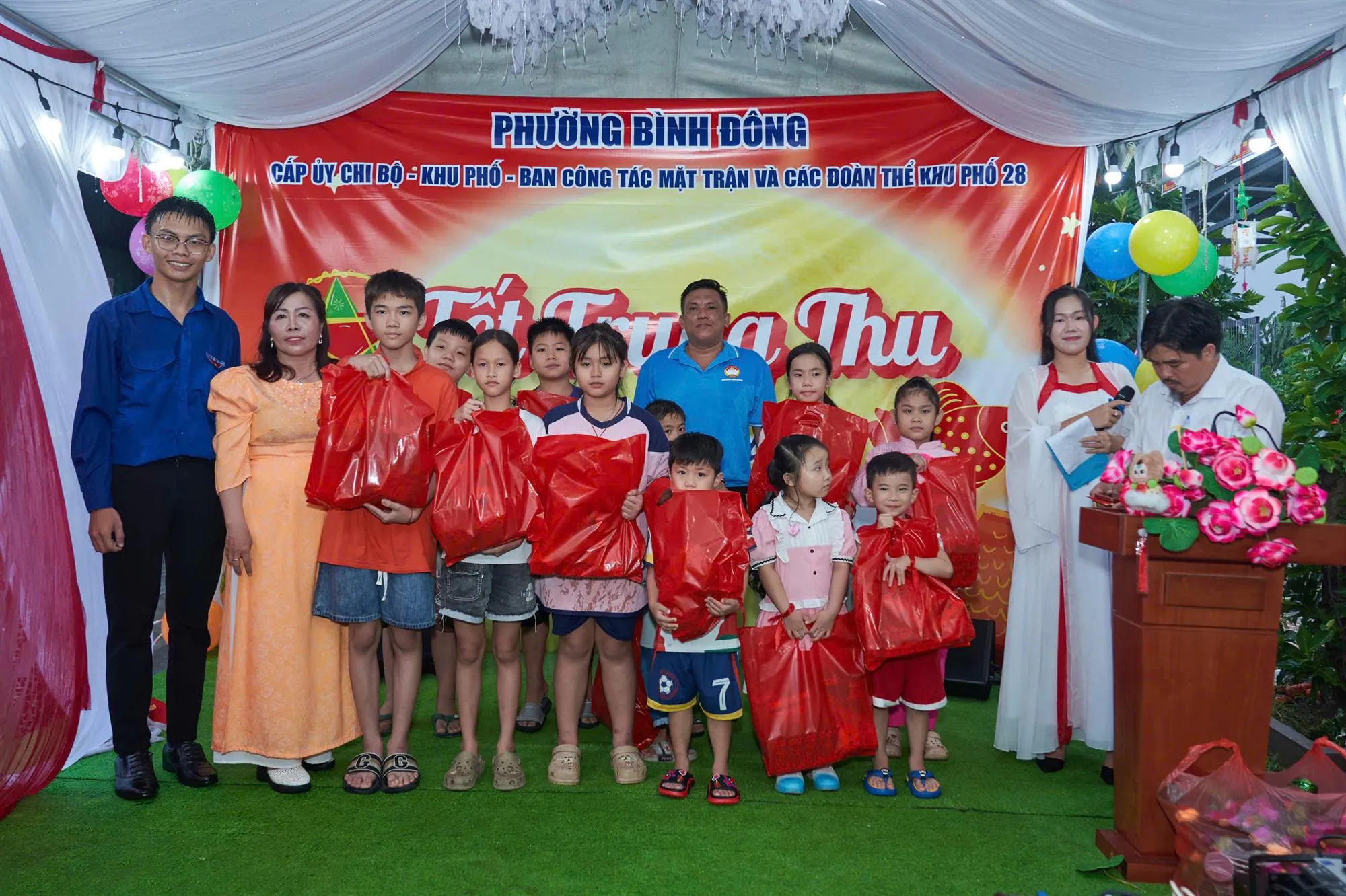 Đồng chí Huỳnh Mỹ Ngọc, Phó Bí thư thường trực Đảng ủy phường Bình Đông cùng Bí thư chi bộ khu phố và ban ngành đoàn thể khu phố 28 trao quà đến các em thiếu nhi