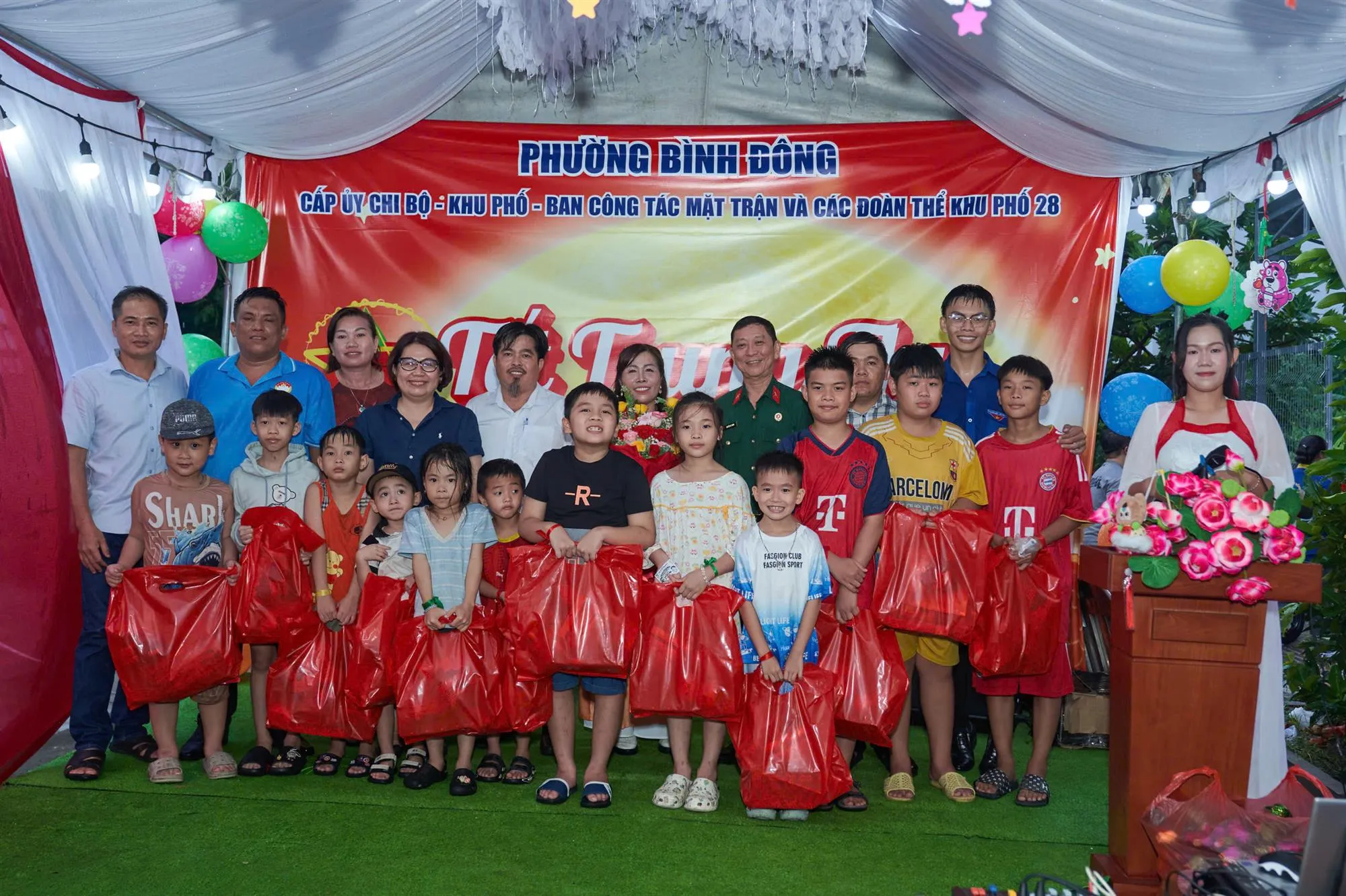 Đồng chí Huỳnh Mỹ Ngọc, Phó Bí thư thường trực Đảng ủy phường Bình Đông cùng Bí thư chi bộ khu phố và ban ngành đoàn thể khu phố 28 trao quà đến các em thiếu nhi