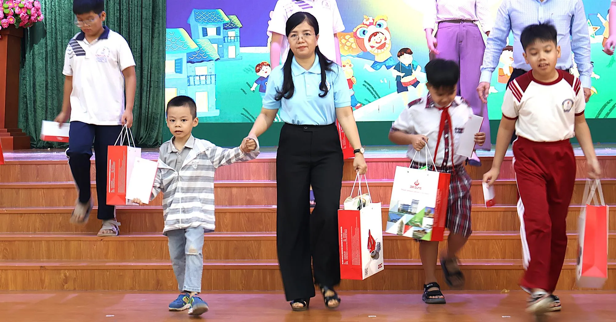 Bà Trịnh Thị Thanh, Phó Chủ tịch thường trực Hội Liên hiệp Phụ nữ Thành phố cùng các đại biểu và nhà tài trợ trao quà cho hơn 200 em mồ côi, có hoàn cảnh khó khăn - Ảnh: Kim Anh
