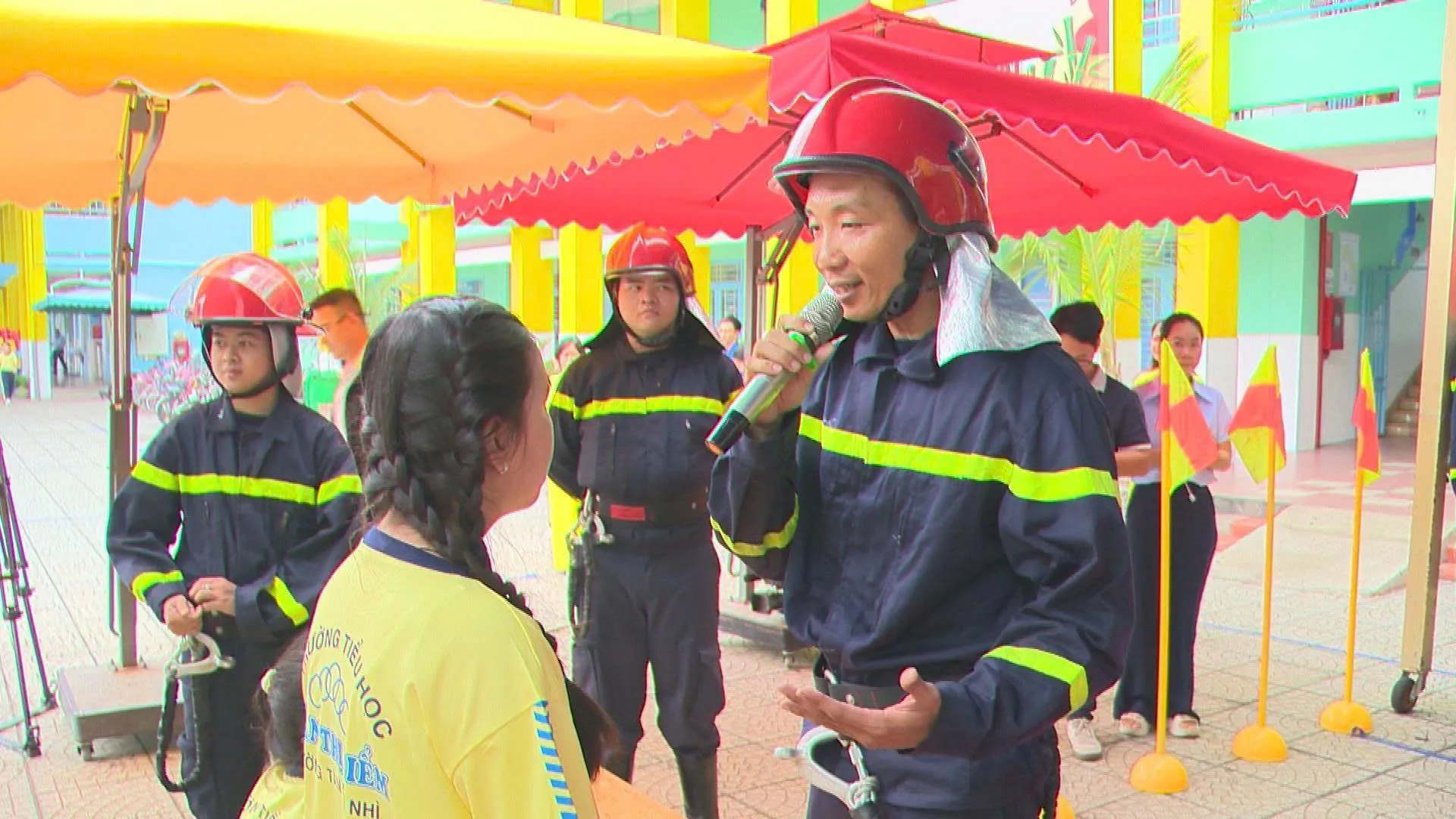 Học sinh chăm chú lắng nghe và quan sát cán bộ PCCC hướng dẫn cách sử dụng vòi chữa cháy và các phương tiện dập lửa ban đầu