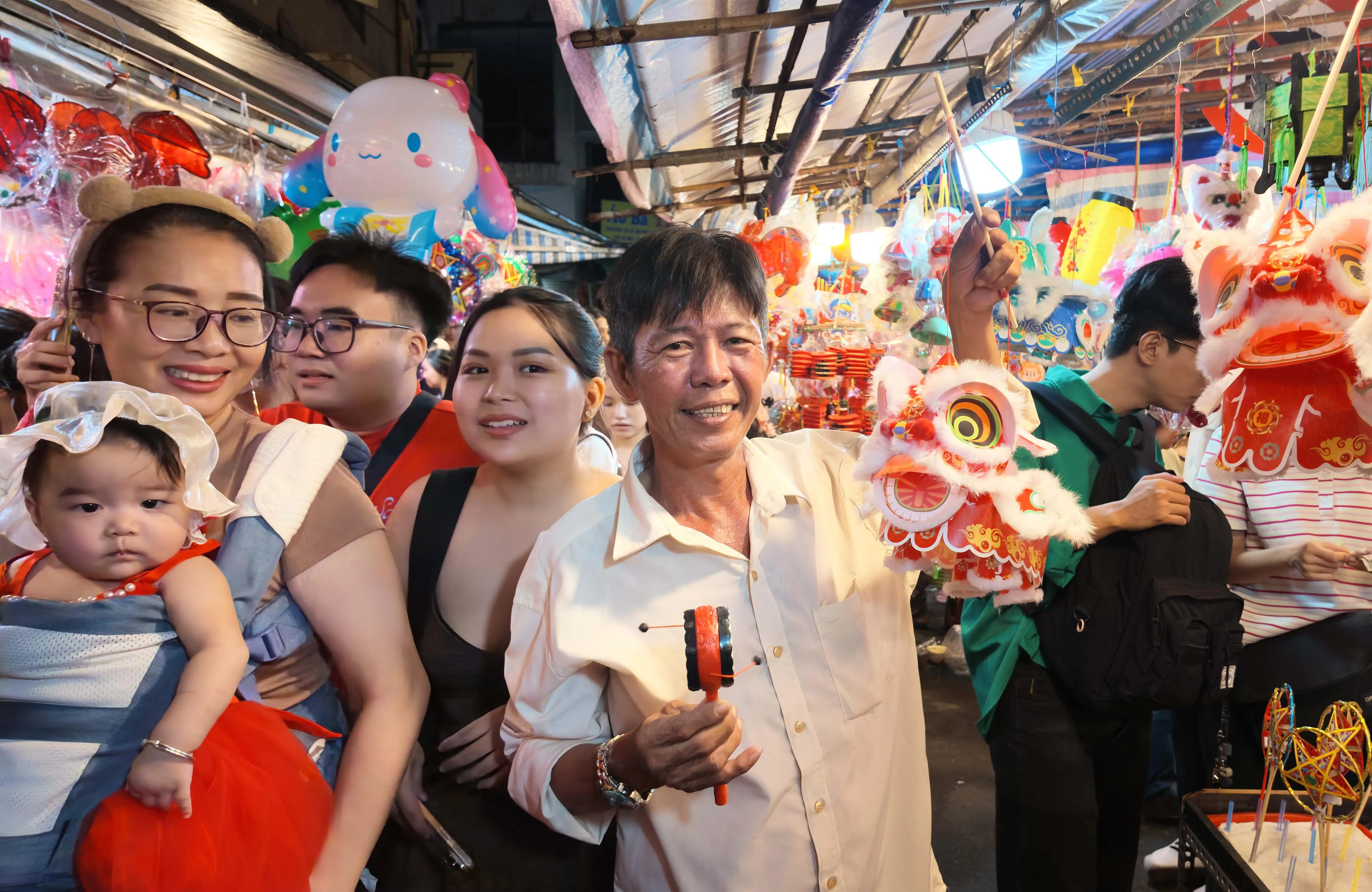 Ông Long Vân Bó giới thiệu mẫu lồng đèn hình con lân có giá 70.000 đồng, được nhiều khách quan tâm trong mùa Trung thu năm nay - Ảnh: Văn Phúc