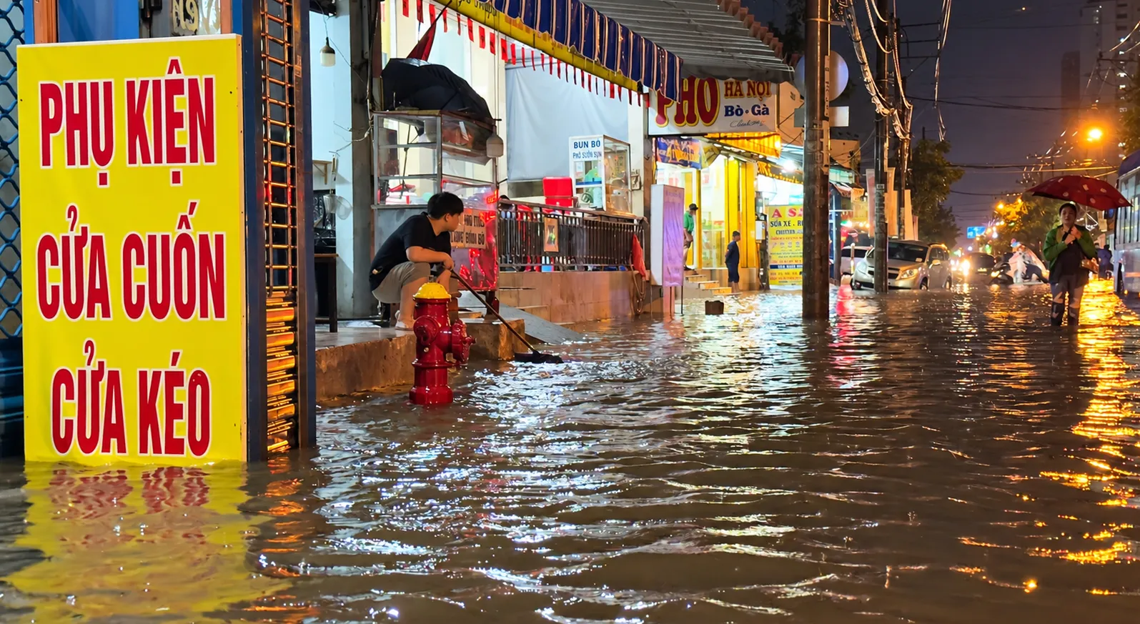 Nước ngập tràn sát hàng quán hai bên đường Mã Lò, ảnh hưởng việc kinh doanh của người dân - Ảnh: Văn Phúc.