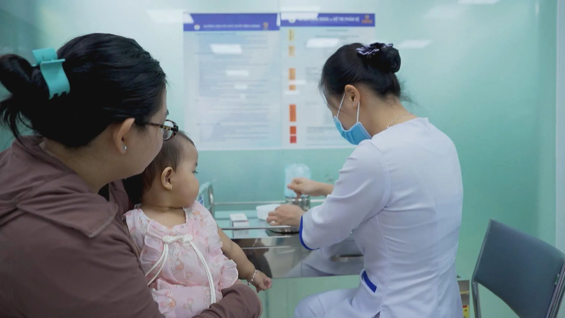 Nhân viên y tế chuẩn bị vắc xin trước khi tiêm cho trẻ tại trung tâm tiêm chủng