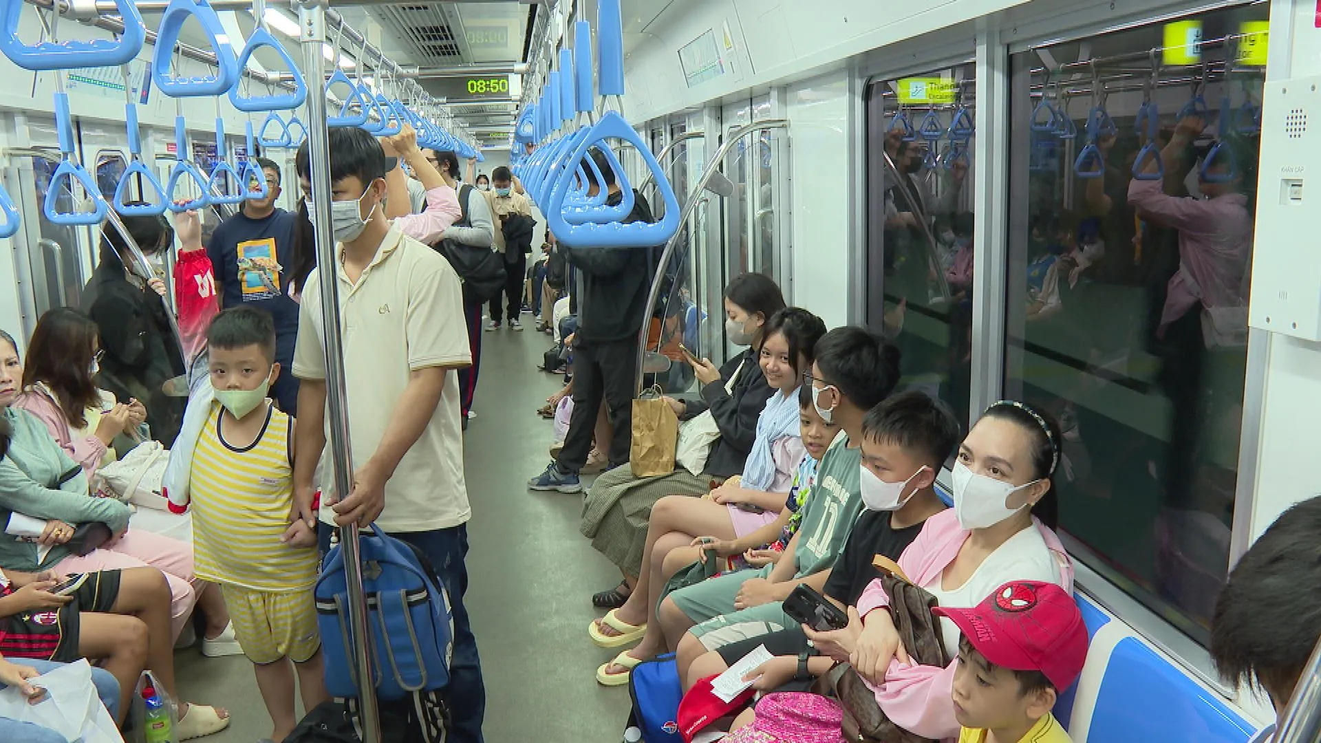 Hành khách trên tuyến Metro số 1 trong giờ hoạt động, trong đó có nhiều gia đình và trẻ em