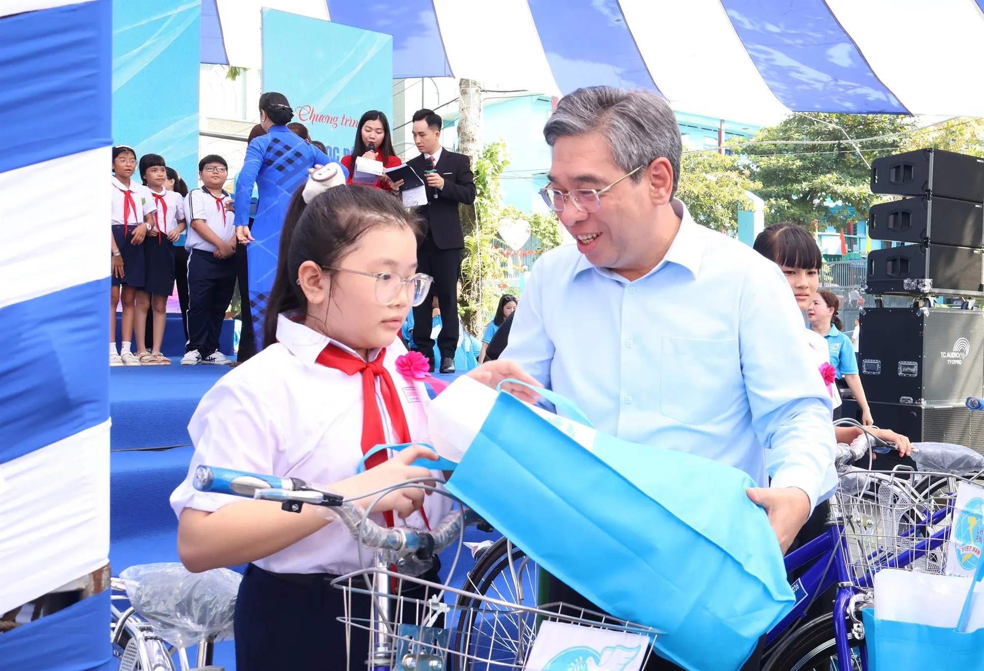Chương trình trao quà cho phụ nữ có hoàn cảnh khó khăn cùng học bổng và xe đạp đến các em học sinh - Ảnh: Kim Anh