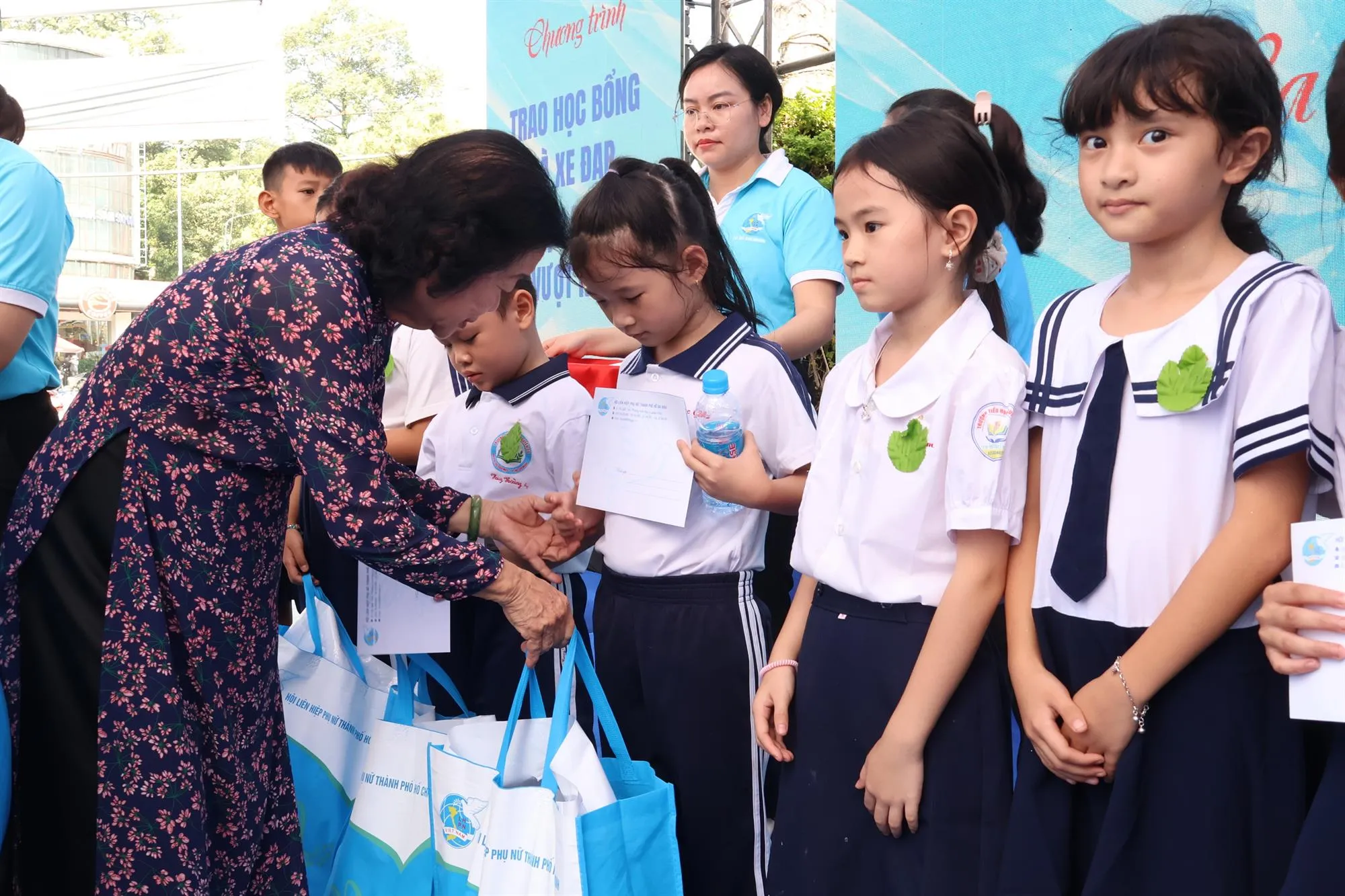 Chương trình trao quà cho phụ nữ có hoàn cảnh khó khăn cùng học bổng và xe đạp đến các em học sinh - Ảnh: Kim Anh