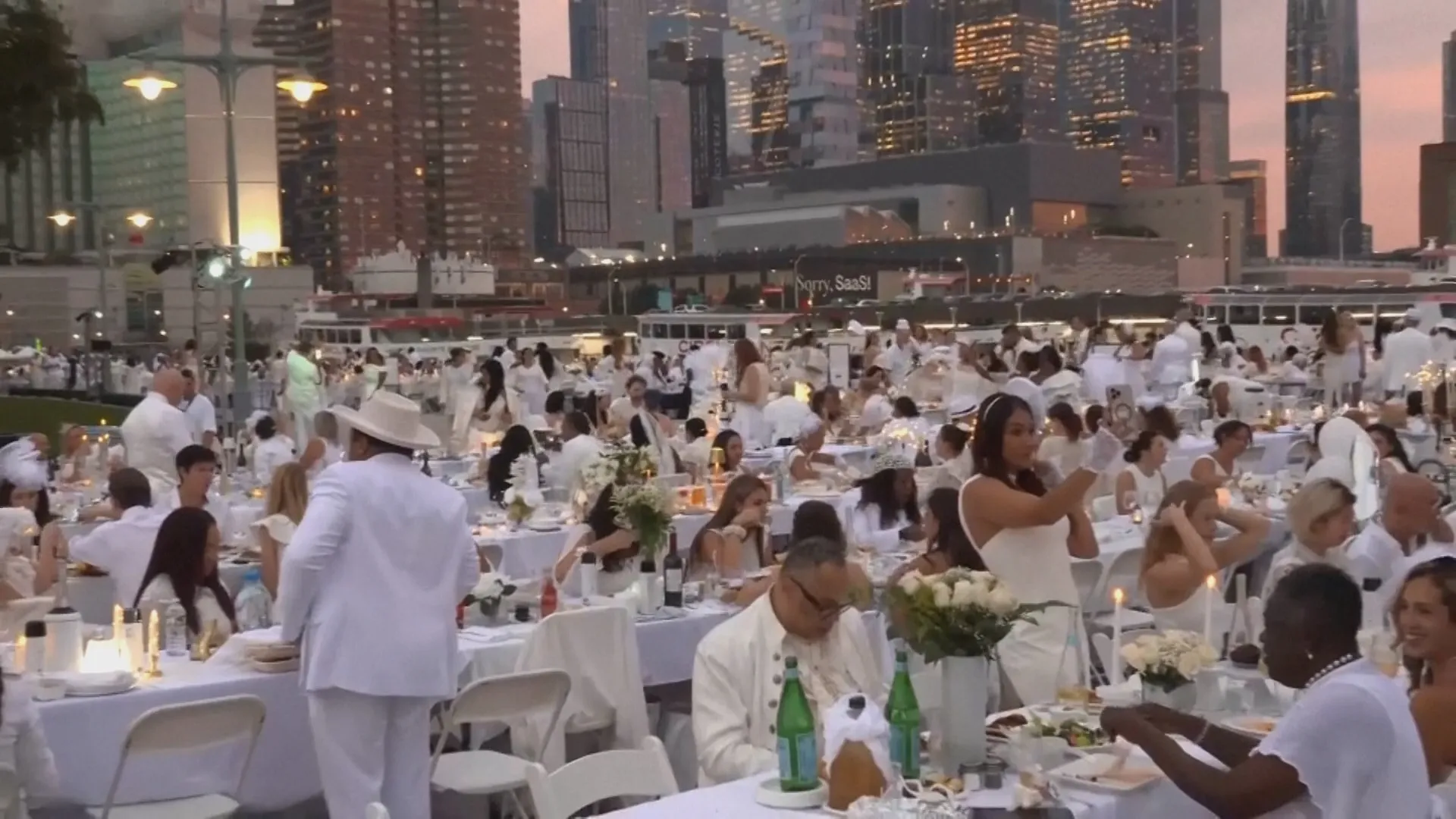 Toàn cảnh không gian lãng mạn của bữa tiệc dã ngoại Dîner en Blanc bên bờ sông Hudson. Hàng ngàn người tham dự cùng diện trang phục trắng thanh lịch và tự tay chuẩn bị bàn tiệc cho riêng mình