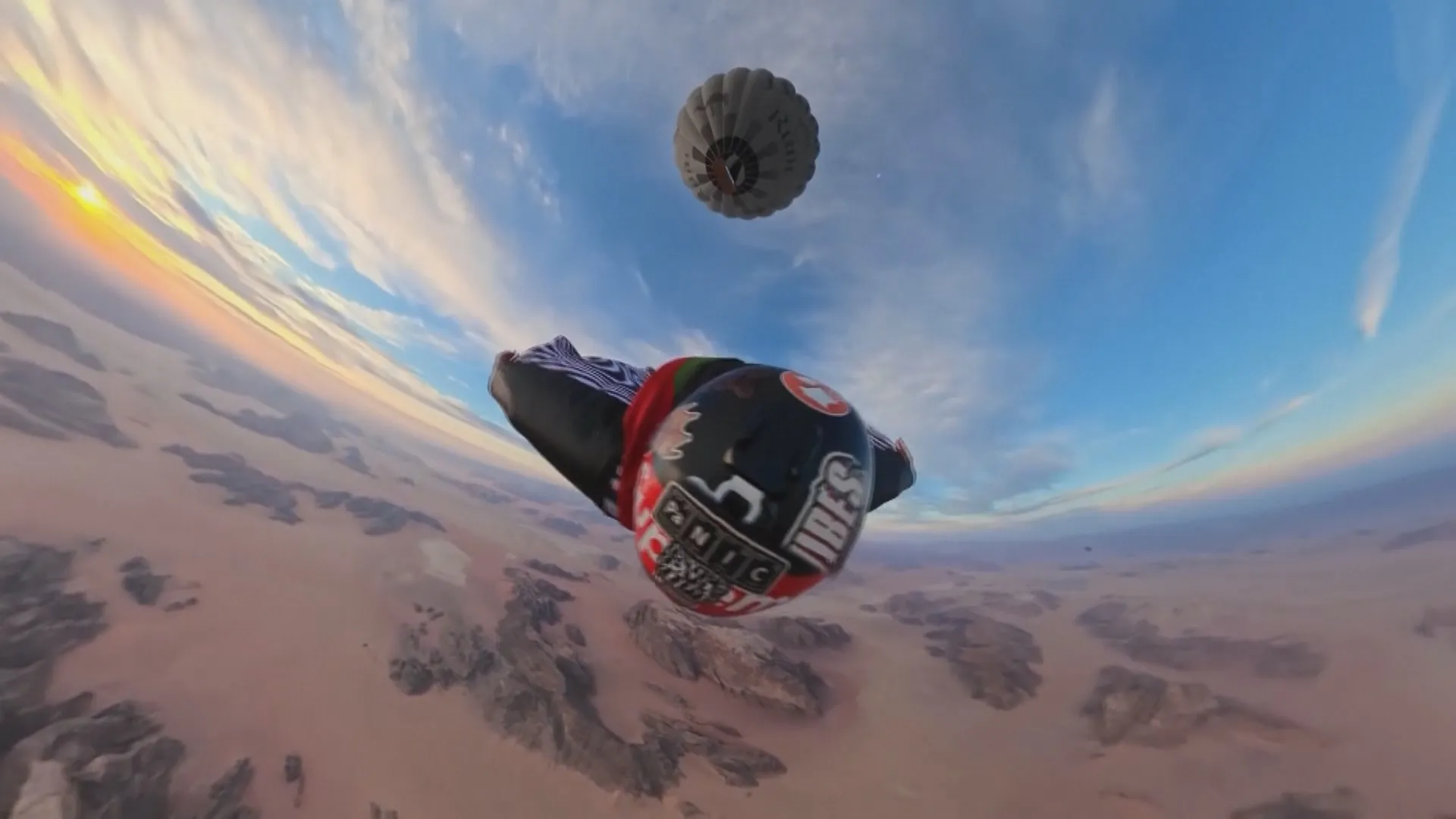 Góc nhìn ngoạn mục từ trên cao khi một vận động viên mặc đồ bay (wingsuit) thực hiện màn rơi tự do sau khi nhảy khỏi giỏ khinh khí cầu